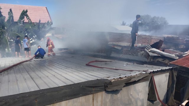 Petugas pemadam kebakaran berusaha memadamkan api di rumah yang terbakar di Jalan Mamoa Rio, Makassar, Kamis (1/7/2021).