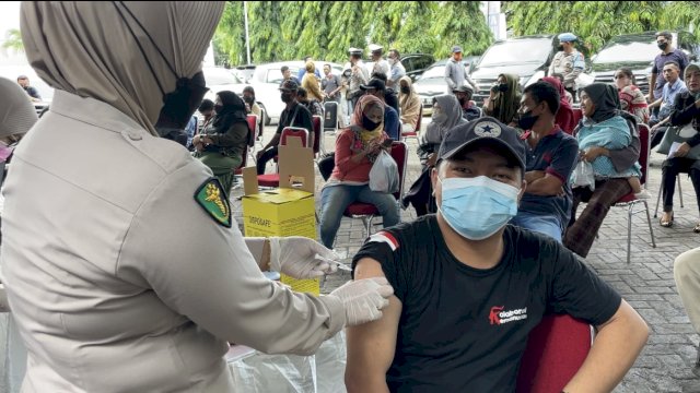 Petugas kesehatan menyuntikkan vaksin covid-19 kepada warga yang datang ke gerai vaksin Samsat Makassar